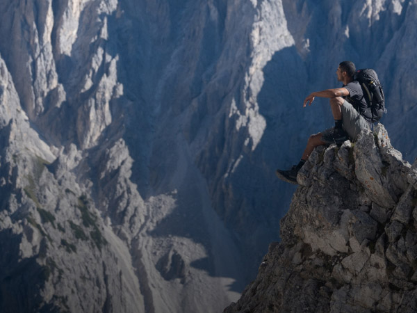 Wanderer sitzt auf einem Berggipfel