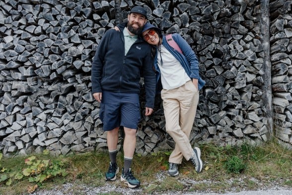 Junge Frau in sportlicher Wanderbekleidung hockt auf einem Felsen in der&nbsp;Dunkelheit